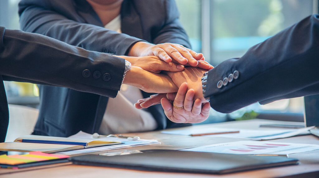 business team stacking their hands on top of eachother